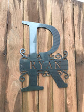 Load image into Gallery viewer, an old metal object hanging from a tree