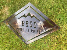 Load image into Gallery viewer, a sign that is sitting in the grass