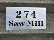Load image into Gallery viewer, a sign on the side of a building